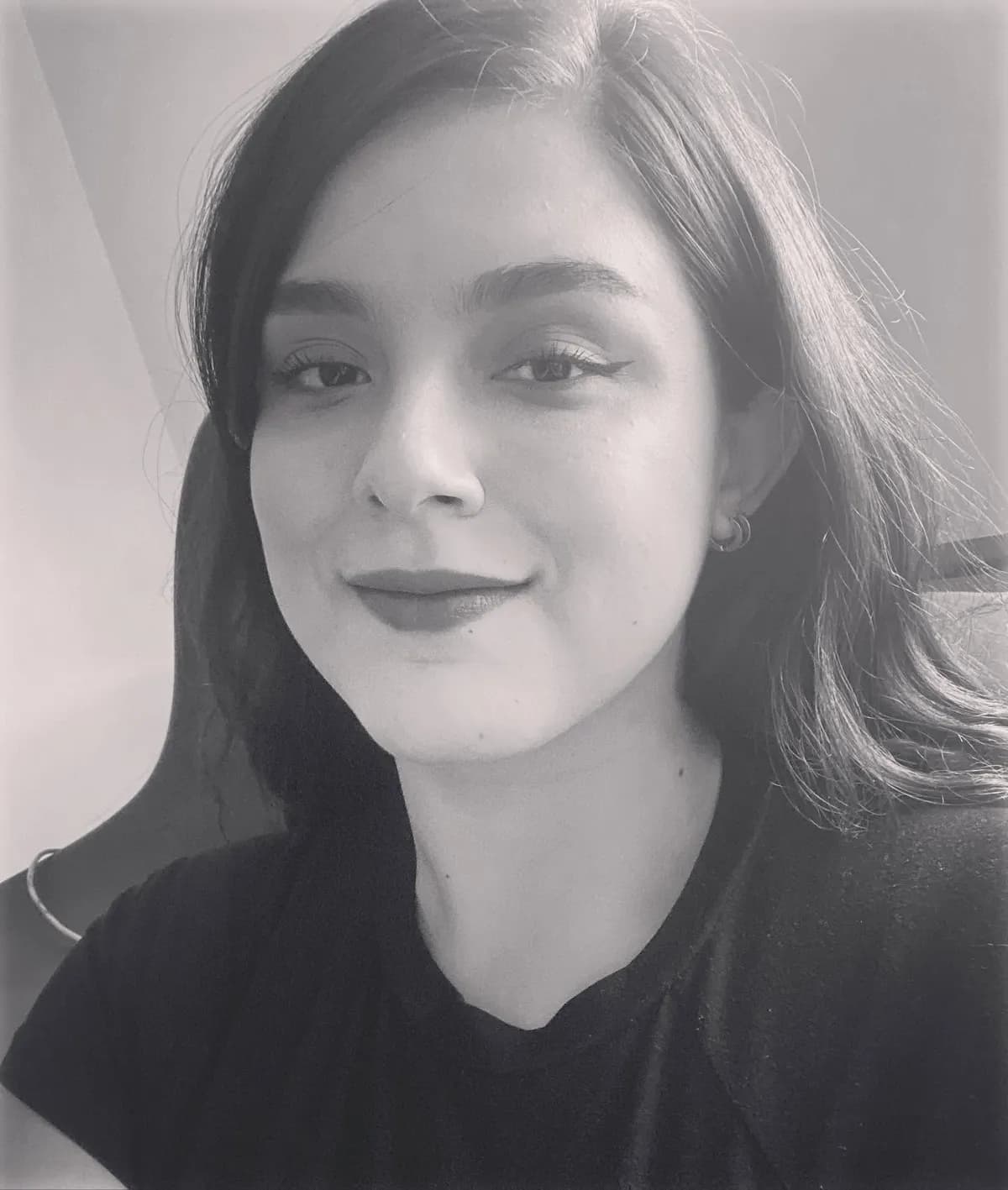 Arely smiling at the camera, in a black-and-white selfie.